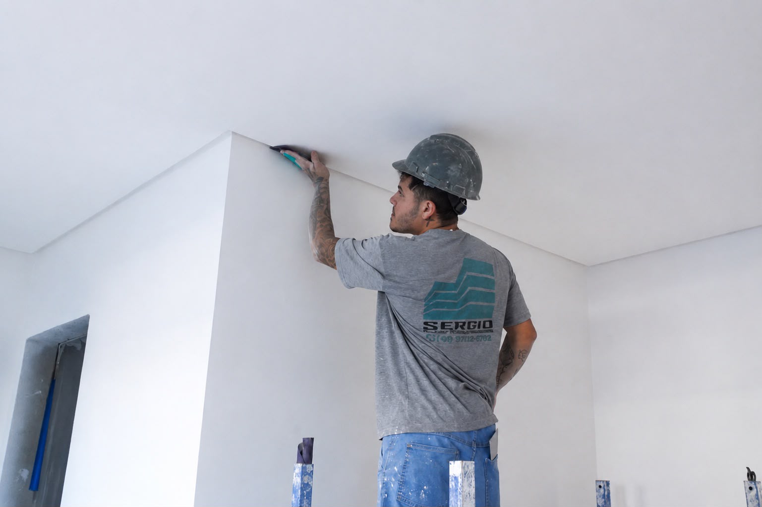 Profissional de pintura predial fazendo acabamento em teto de apartamento em Bombinhas